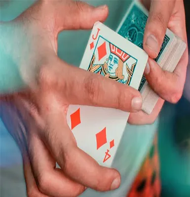 A person holding a playing card in their hands